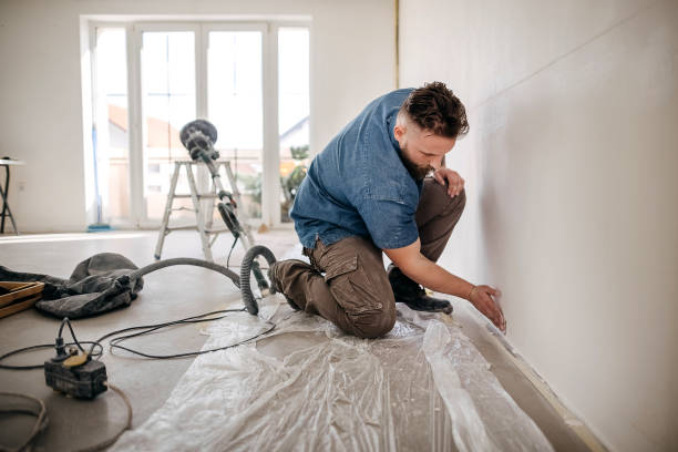 A male worker puts laminate flooring on the floor.