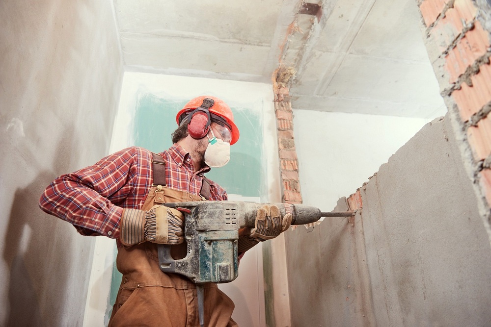 Repairer in boilersuit holding tools. Apartment repair and renovation concept. Building.